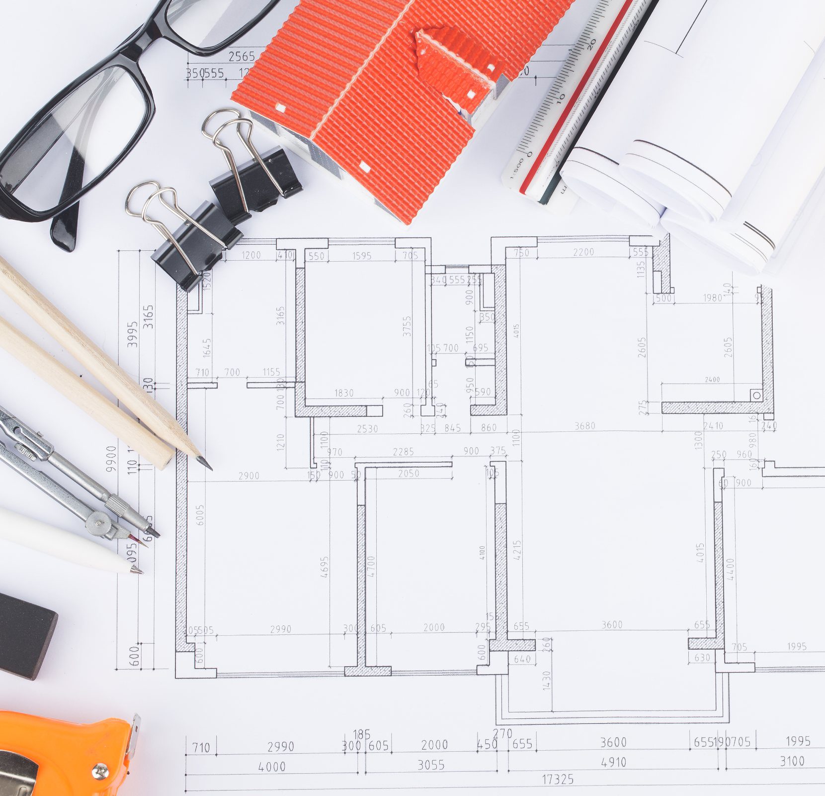 A table with some construction plans and pens