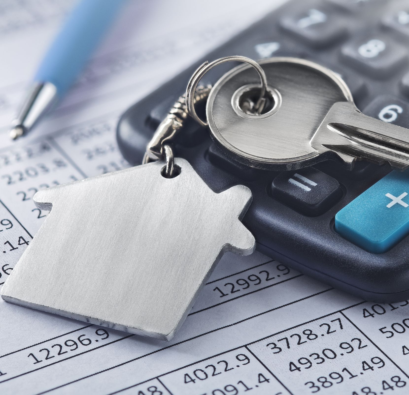 A key and calculator on top of a table.