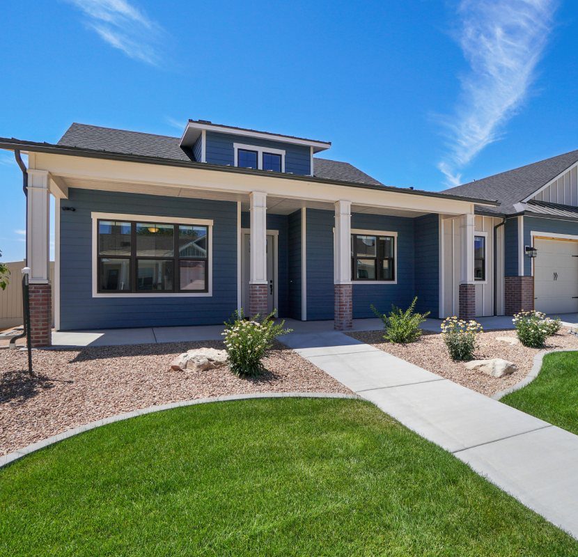 A house with grass and bushes in front of it.
